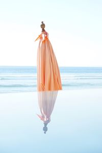 Umbrella on beach against clear sky