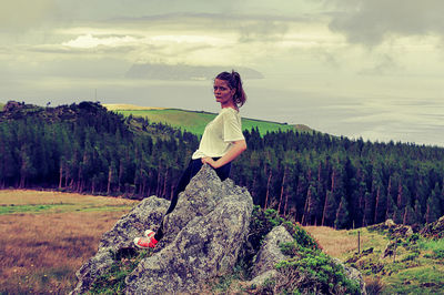 Woman standing by tree against sky