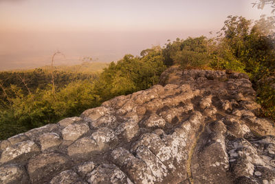 Rocks on land against sky during sunset