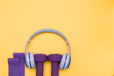 View of exercise equipment with headphones over colored background