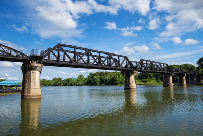 Low angle view of bridge over river against sky