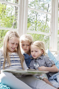 Three girls reading book