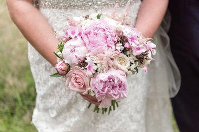 Midsection of woman holding flower bouquet