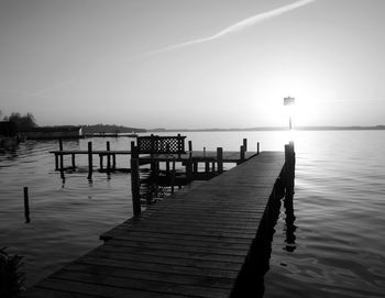 Wooden pier over sea against sky