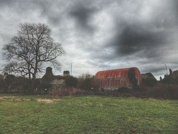 Built structure on field against cloudy sky