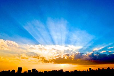 Silhouette vapor trail against sky during sunset