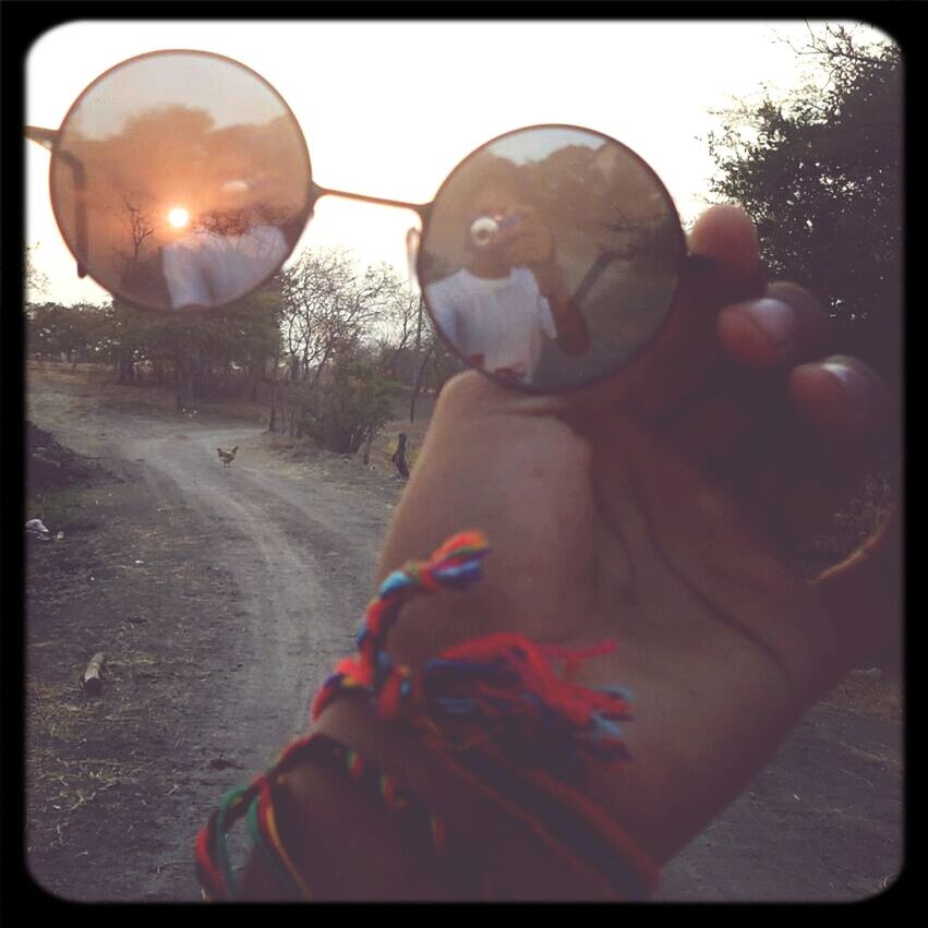 transfer print, auto post production filter, person, holding, lifestyles, leisure activity, close-up, unrecognizable person, part of, sky, human finger, sunlight, outdoors, childhood, day, cropped, personal perspective