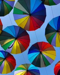 Low angle view of colorful umbrellas hanging against clear sky
