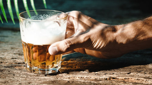 Hand rests glass of beer