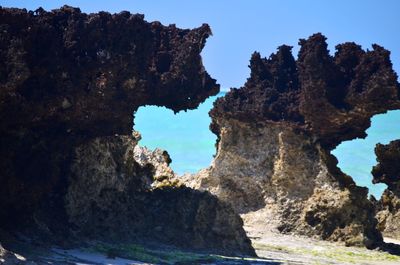 Rock formations by sea against sky