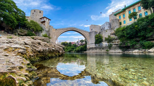 Arch bridge over river against sky