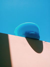 Low angle view of bowl on retaining wall against clear sky