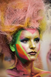 Beautiful young woman with painted face looking away