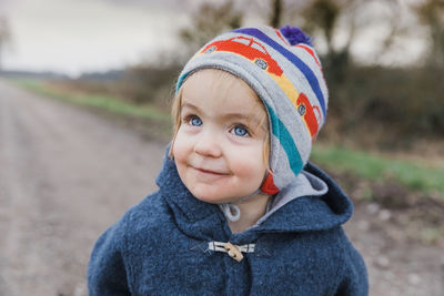 Cute girl in knit hat looking away