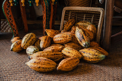 Heap of fresh ripe yellow cocoa pods spilling from basket