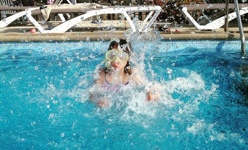 Man splashing water in swimming pool