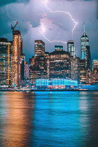 Illuminated buildings in city against sky at night