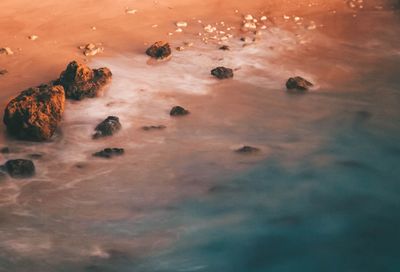 Scenic view of rocks in sea during sunset