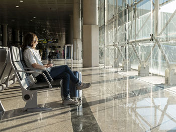 Pretty, young woman waiting at a gate area of a modern airport