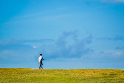 Peria standing on a hill looking at the beautiful beach