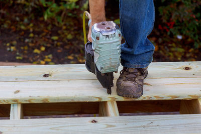 Low section of man standing on wooden plank