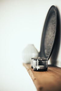 Close-up of hand holding cup against white background