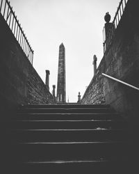 Low angle view of people standing on staircase against sky