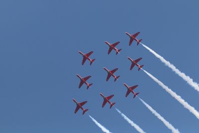 Low angle view of airshow against sky