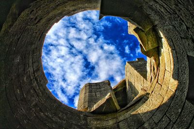 Low angle view of blue sky seen through hole