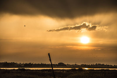 Scenic view of silhouette field against sky during sunset