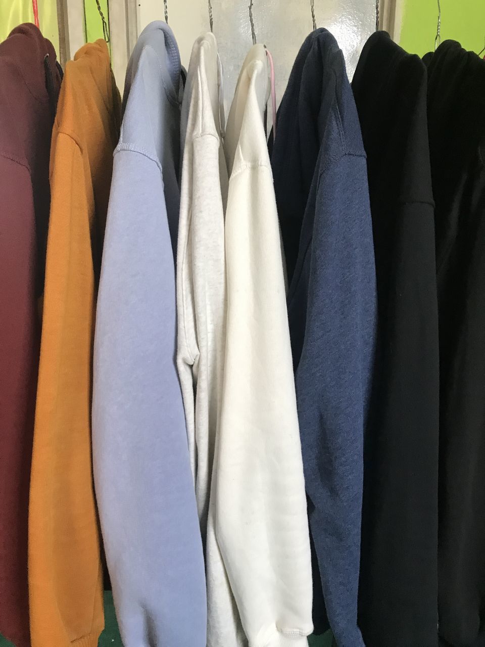 MIDSECTION OF CLOTHES HANGING ON RACK