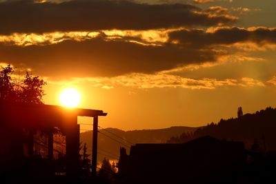 Silhouette buildings against sky during sunset