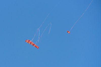 Low angle view of kite flying against clear blue sky