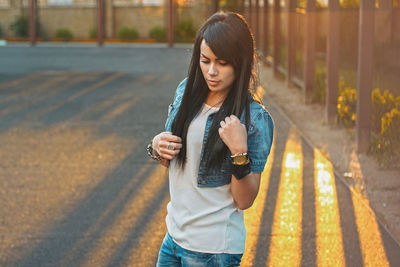 Full length of young woman standing on road