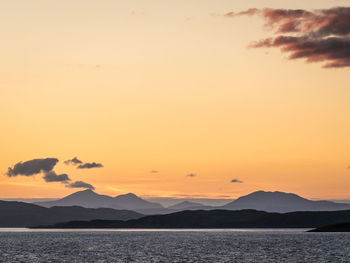 Scenic view of calm sea against orange sky