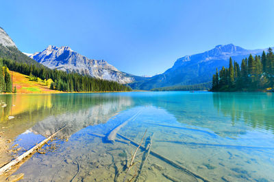 Scenic view of lake and mountains against blue sky