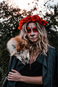 Happy halloween concept. scared horrible female sitting in special outfit, wears white clay skull