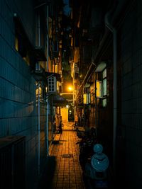 Illuminated street amidst buildings at night