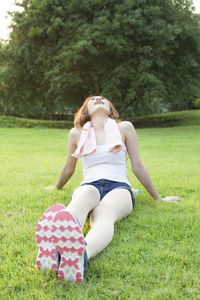Full length of young woman sitting on grass