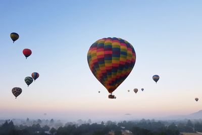 Low angle view of hot air balloons against sky during sunrise