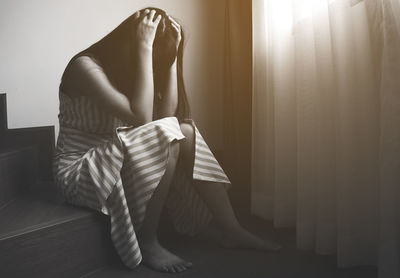 Midsection of woman sitting at home