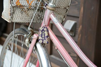 Close-up of pink bicycle with omamori charm