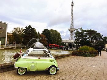 Vintage car in city against cloudy sky