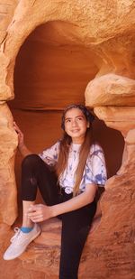 Smiling girl sitting on rock