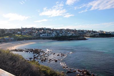 High angle view of townscape by sea against sky