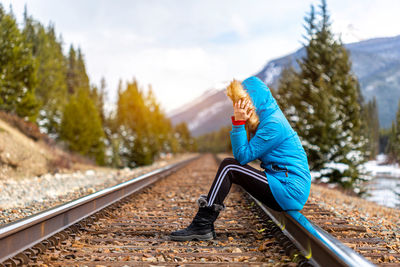 Side view of woman on railroad track