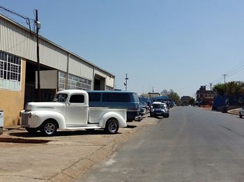 Cars on road in city against clear sky