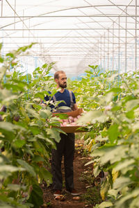 Portrait of woman standing amidst plants