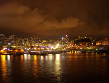 Illuminated cityscape against sky at night