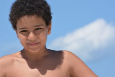 Portrait of teenage boy smiling against sky